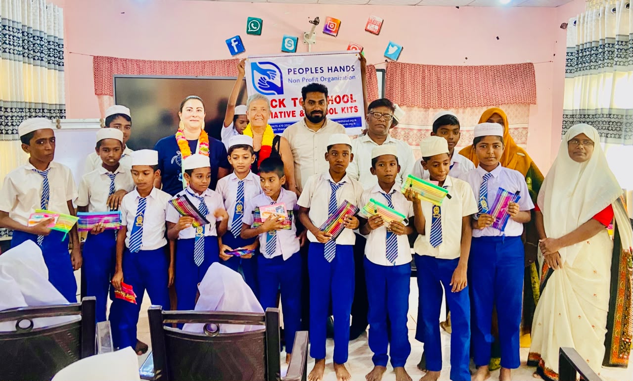 Amandine from France with students and People's Hands Organization staff during the Back to School school kit distribution at T/Mohamadiya Vidyalayam, Iqbalnagar, Kuchchaveli, Trincomalee